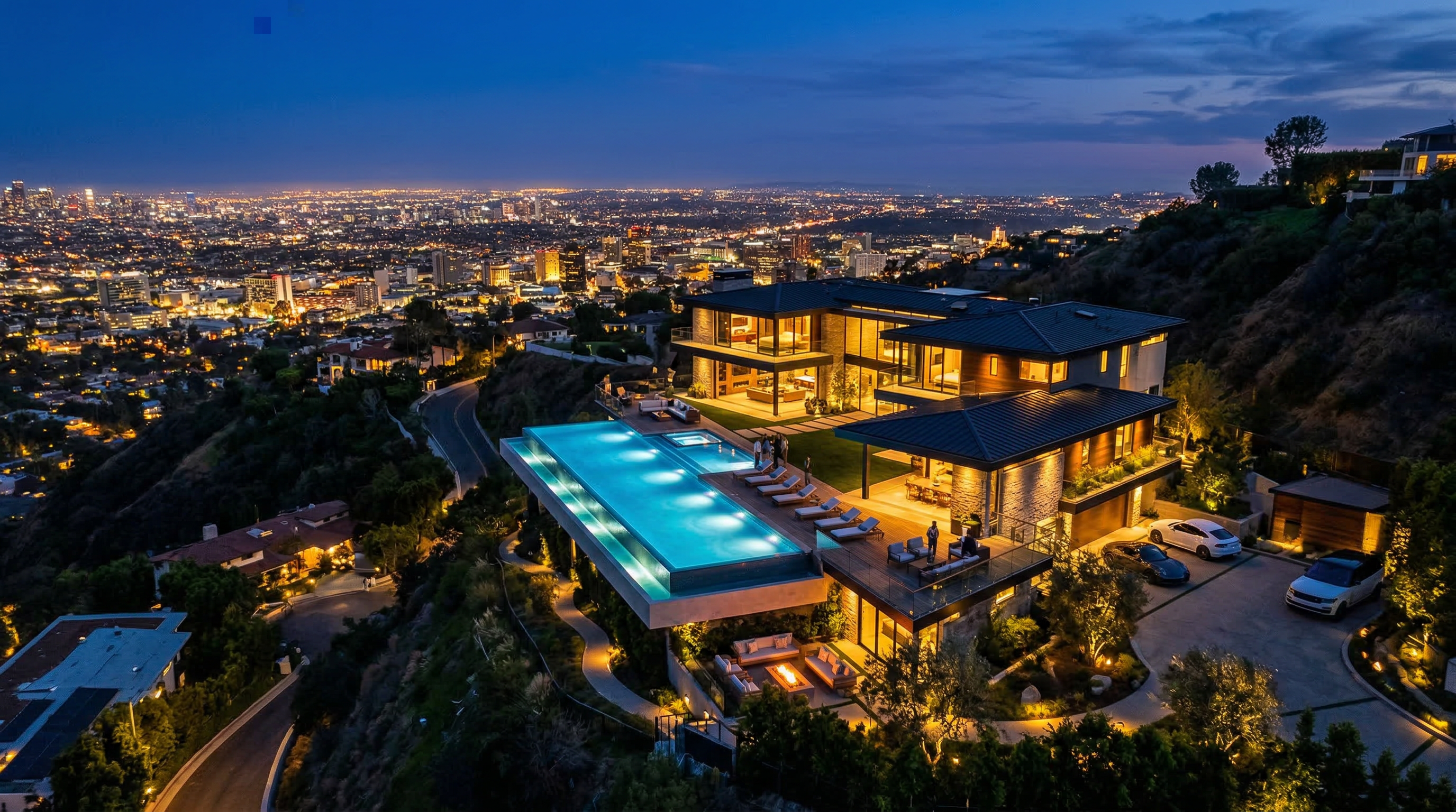 Luxury hillside estate with infinity pool overlooking city lights at twilight
